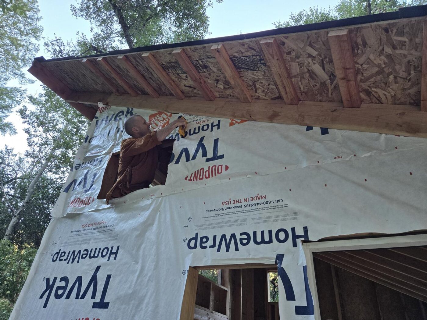 Ajahn Nisabho staples Tyvek at Karuna Buddhist Vihara